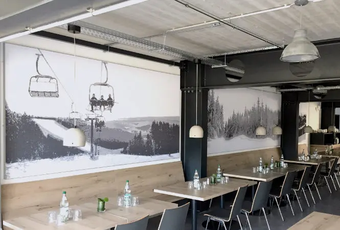 Raumklang verbessern mit Akustikbild – stilvoll und wirksam Akustikbild an der Wand eines Restaurants zur Schallminderung