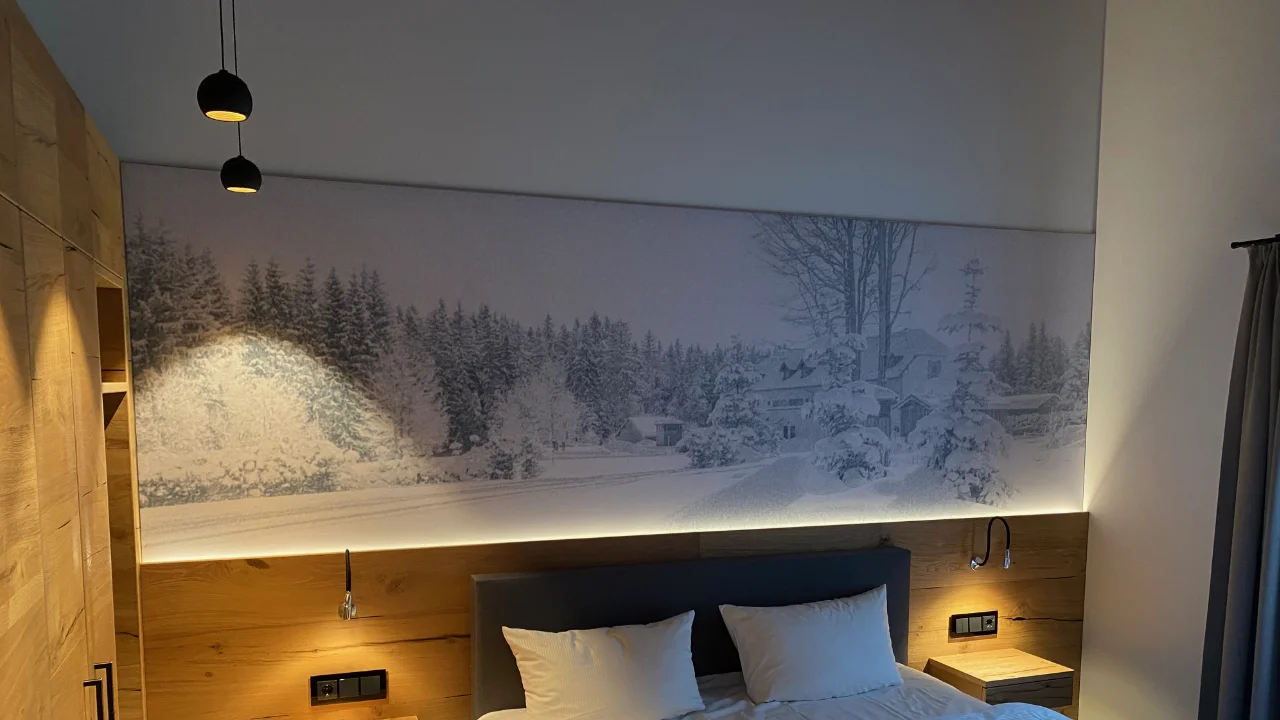 Breites Akustikbild mit fotorealistischer Winterlandschaft über dem Bettkopfteil, indirekt beleuchtet, im Hotelzimmer