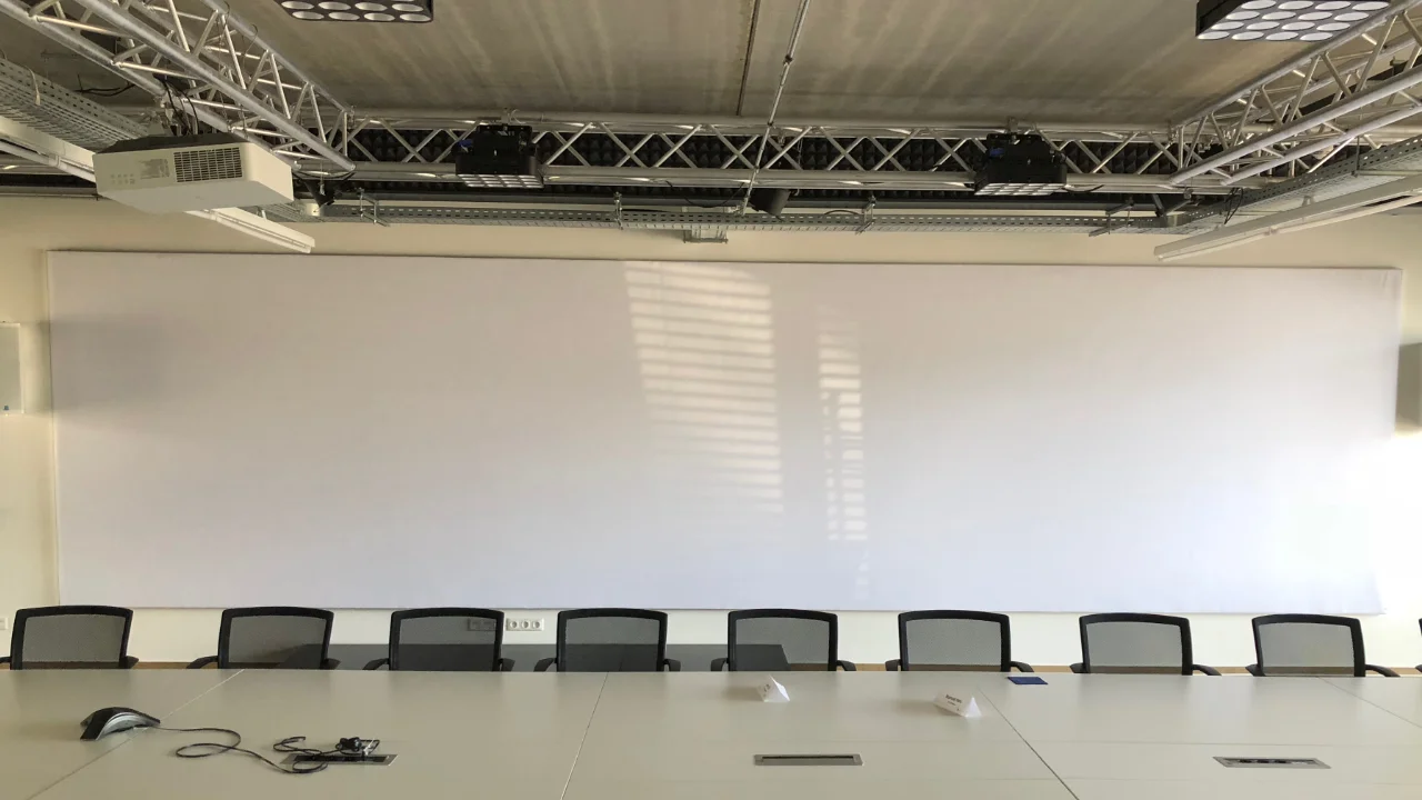Videokonferenzraum mit schallabsorbierender Videoleinwand und großformatigen Akustikbildern
