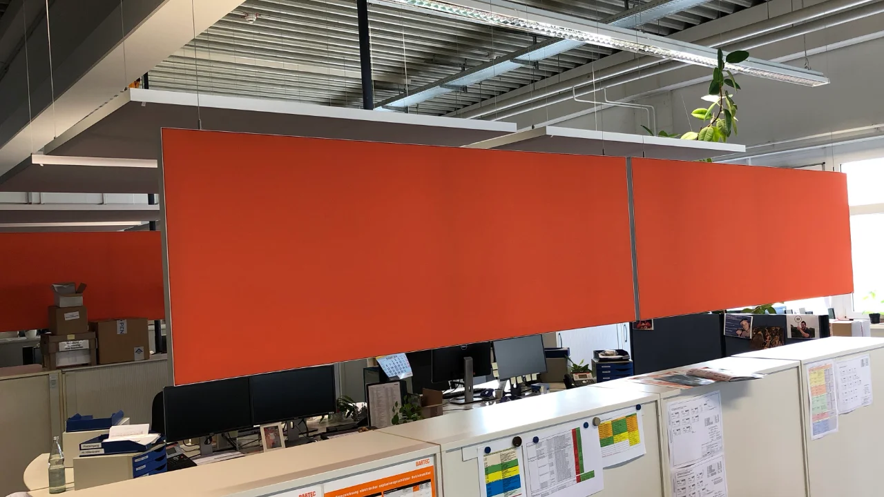 Service-Desk-Bereich einer Industriehalle mit Akustik-Deckensegeln und Baffles