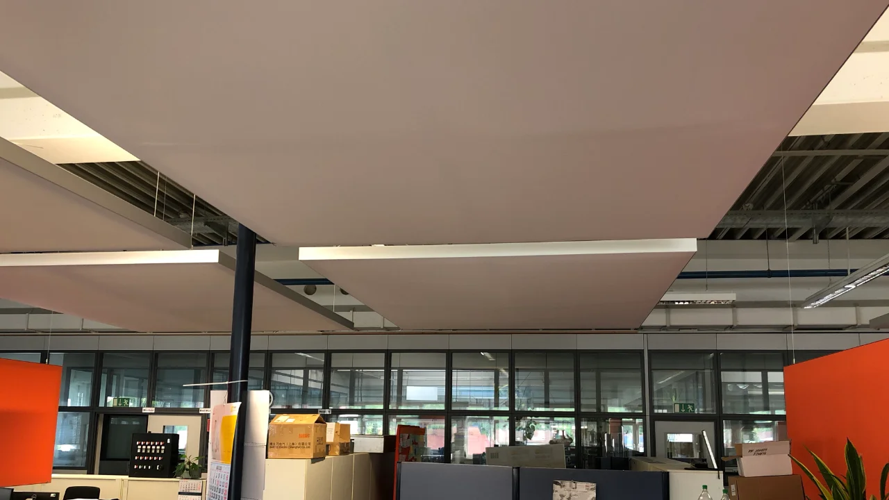 Gezielte Zonenlösung am Service Desk einer 400 m² großen Industriehalle mit kombinierten Deckensegeln und mobilen Stellwänden